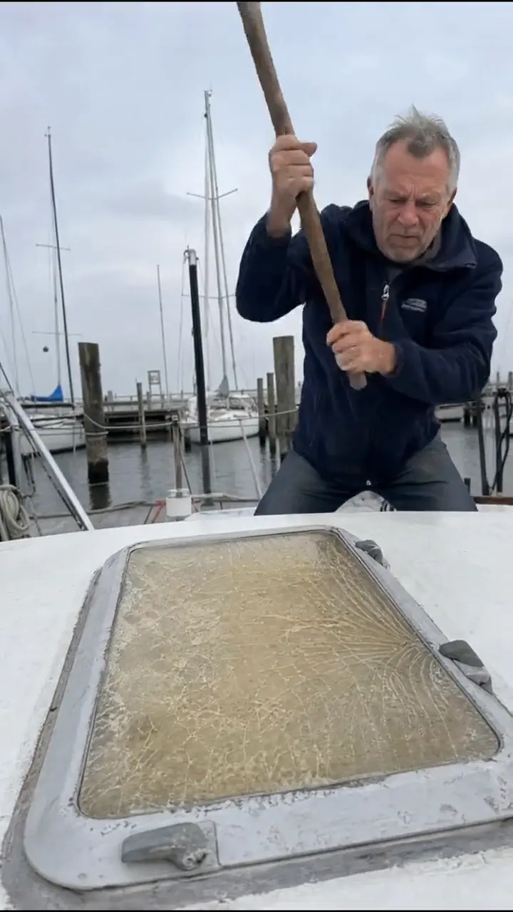 Still from a MarinAcryl Reel: an old boat hatch is knocked out